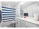 Clean bathroom featuring a tub with a blue striped shower curtain and vanity at 1009 Haynoke Dr, Graham, NC 27253