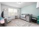 Cozy Bedroom with crib, rocking chair, soft rug, and a bright window at 1009 Haynoke Dr, Graham, NC 27253