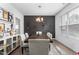 Sophisticated dining room featuring modern lighting, a dark accent wall, and views of the landscaped exterior at 1009 Haynoke Dr, Graham, NC 27253