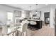 Bright kitchen with gray cabinets, granite countertops, an island with barstools, and an adjacent dining area at 1009 Haynoke Dr, Graham, NC 27253