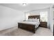 Bright main bedroom featuring neutral walls and carpet with a wooden bed frame at 1009 Haynoke Dr, Graham, NC 27253
