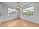 Sunny dining area featuring large windows and hardwood floors with modern light fixture at 10410 Rosegate Ct # 307, Raleigh, NC 27617