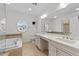 Bright bathroom featuring double sinks, a bathtub, and a round window at 10410 Rosegate Ct, Raleigh, NC 27617