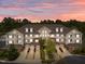 Beautiful exterior view of a multi-unit townhome complex highlighting garages and sunset sky at 10410 Rosegate Ct, Raleigh, NC 27617