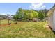 Landscaped backyard featuring a manicured lawn, mulch beds, trees and a small outdoor shed at 109 E Fayetteville St, Micro, NC 27555
