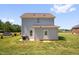 View of backyard with patio, grill, grass, and the home's gray vinyl siding at 109 E Fayetteville St, Micro, NC 27555