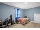 A bright bedroom with a blue painted walls, a bed and a window with blue sheer curtains at 109 E Fayetteville St, Micro, NC 27555