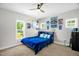 Bright bedroom with a blue bed, ceiling fan, and two windows at 109 E Fayetteville St, Micro, NC 27555