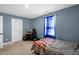 A well-lit bedroom featuring blue painted walls and a bed by a window with sheer blue curtains at 109 E Fayetteville St, Micro, NC 27555