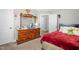 Comfortable bedroom featuring a wooden dresser with a large mirror and a red plush comforter at 109 E Fayetteville St, Micro, NC 27555