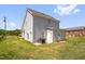 View of the backyard with grass, grill and the gray vinyl siding of the home at 109 E Fayetteville St, Micro, NC 27555