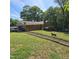 Spacious backyard with wooden deck, mature trees and partial chain link fence in place at 1102 Parkwood Dr, Siler City, NC 27344