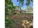Two-story home surrounded by trees and nature featuring a brick facade and well-maintained landscaping at 1102 Parkwood Dr, Siler City, NC 27344