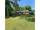 Charming brick home with a sprawling front yard, complemented by lush greenery and mature trees at 1102 Parkwood Dr, Siler City, NC 27344