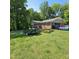 Home with a two-car garage and lawn care equipment on a trailer in the driveway at 1102 Parkwood Dr, Siler City, NC 27344