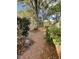 The brick walkway shows a large tree and a lush backyard at 112 Hilton Ave, Durham, NC 27707