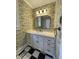 Charming bathroom with a white vanity, black and white floors, and vintage-style wallpaper at 112 Hilton Ave, Durham, NC 27707