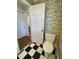 Neat bathroom with black and white checkered floors and quaint toile wallpaper at 112 Hilton Ave, Durham, NC 27707