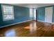Bright bedroom featuring beautiful hardwood floors, fresh paint, and natural light from two windows at 112 Hilton Ave, Durham, NC 27707