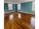 Empty bedroom with beautiful hardwood floors and lots of natural light from three windows at 112 Hilton Ave, Durham, NC 27707