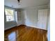 A bedroom with wood floors, a white bookcase, and two white doors at 112 Hilton Ave, Durham, NC 27707