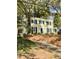 View of the home with mature trees, showing the yard and driveway at 112 Hilton Ave, Durham, NC 27707