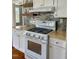 Kitchen featuring stainless steel range with butcher block counters and mosaic tile backsplash at 112 Hilton Ave, Durham, NC 27707