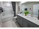 Bright bathroom with double vanity, gray cabinets, tiled floors, and a shower-tub combo at 1139 Winding Spring Dr, Mebane, NC 27302