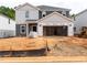 Two-story home exterior showcasing gray and white siding, attached two-car garage, and construction in progress at 1139 Winding Spring Dr, Mebane, NC 27302