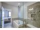 Modern bathroom with tub and glass enclosed shower with tile surround adjoins the main bedroom at 124 Shale Creek Dr, Durham, NC 27703