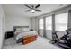 Bright bedroom features large windows, gray walls, ceiling fan, and a Peloton exercise bike at 124 Shale Creek Dr, Durham, NC 27703