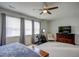 Bright bedroom features large windows, gray walls, ceiling fan, a Peloton, and a TV at 124 Shale Creek Dr, Durham, NC 27703