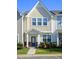 Charming townhome featuring a blue front door and manicured landscaping at 124 Shale Creek Dr, Durham, NC 27703
