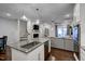 Kitchen island boasts granite countertops, stainless steel appliances, and an open view into the living room and staircase at 124 Shale Creek Dr, Durham, NC 27703