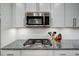 Close up on kitchen stainless steel gas range, microwave, granite countertops, and white subway tile backsplash at 124 Shale Creek Dr, Durham, NC 27703