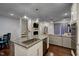 Kitchen island boasts granite countertops, stainless steel appliances, and an open view into the living room and staircase at 124 Shale Creek Dr, Durham, NC 27703