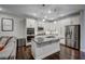 Well-lit kitchen features stainless steel appliances, granite countertops, and a spacious central island with sink at 124 Shale Creek Dr, Durham, NC 27703