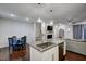 The modern kitchen island is complete with granite countertops, stainless steel appliances, and an open floor plan at 124 Shale Creek Dr, Durham, NC 27703