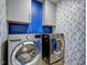 Modern laundry room with stainless steel washer and dryer, plus stylish wallpaper at 124 Shale Creek Dr, Durham, NC 27703