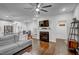 Open-concept living room featuring a cozy fireplace, ceiling fan, and hardwood floors at 124 Shale Creek Dr, Durham, NC 27703
