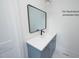 Bathroom vanity featuring blue cabinetry, white countertop, black hardware, and a modern mirror at 12845 Mallard Rock Rd, Zebulon, NC 27597