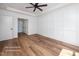 Bright bedroom with hardwood floors, paneled accent wall, ceiling fan, and en-suite bathroom at 12845 Mallard Rock Rd, Zebulon, NC 27597