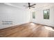 Bright bedroom with hardwood floors, paneled accent wall, ceiling fan, and windows at 12845 Mallard Rock Rd, Zebulon, NC 27597