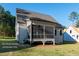 Home featuring a screened-in back porch overlooking a spacious lawn and landscaping at 12845 Mallard Rock Rd, Zebulon, NC 27597