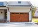 A carriage garage door with decorative windows and natural wood finish at 12845 Mallard Rock Rd, Zebulon, NC 27597