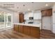 Modern kitchen featuring white cabinets, hardwood flooring, and a large center island at 12845 Mallard Rock Rd, Zebulon, NC 27597