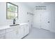 Bright laundry room featuring white cabinets with gold pulls and a stylish sink and faucet at 12845 Mallard Rock Rd, Zebulon, NC 27597