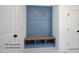Custom blue mudroom with wooden bench, storage cubbies, and decorative lighting at 12845 Mallard Rock Rd, Zebulon, NC 27597