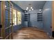 Stylish home office featuring beautiful blue walls, built in shelving, and hardwood flooring at 12845 Mallard Rock Rd, Zebulon, NC 27597