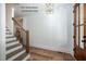 Stylish staircase with light hardwood flooring, white trim, and modern black railings at 12845 Mallard Rock Rd, Zebulon, NC 27597
